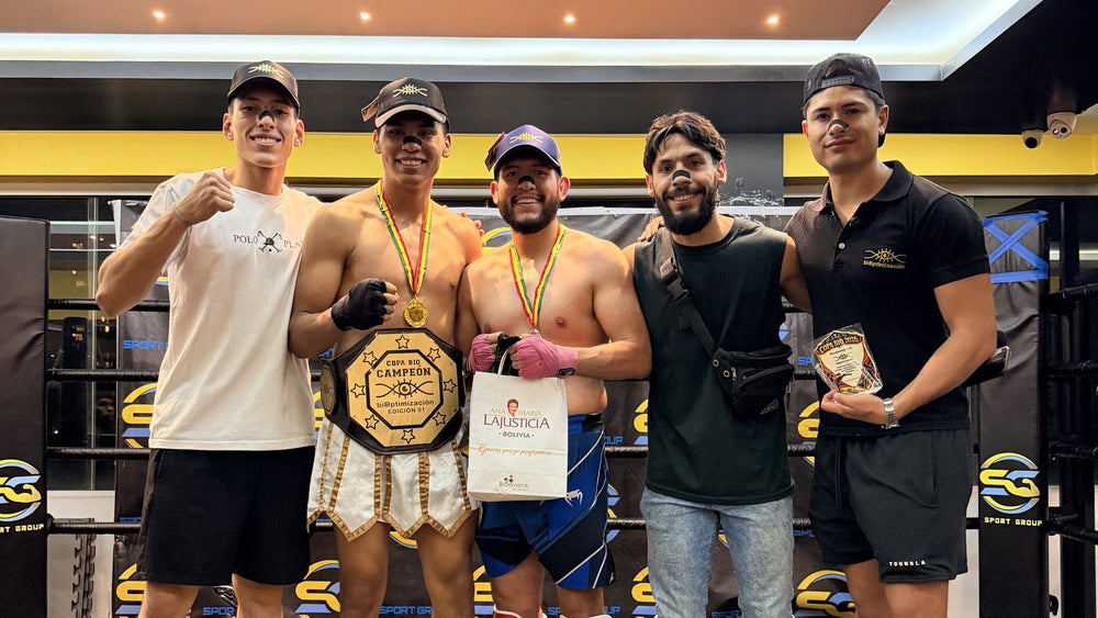 Podio de la Copa BIO 2026 en Sport Group Cochabamba: el campeón Luis García con el cinturón, Claudio Gerónimo Apaza, Gary Enriquez y Enzo Ferrel