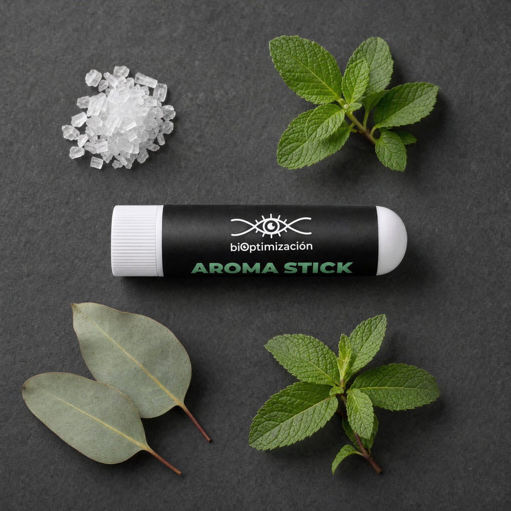 Un Nasal Stick junto a cristales de mentol y hojas de menta verde, eucalipto y menta piperita
