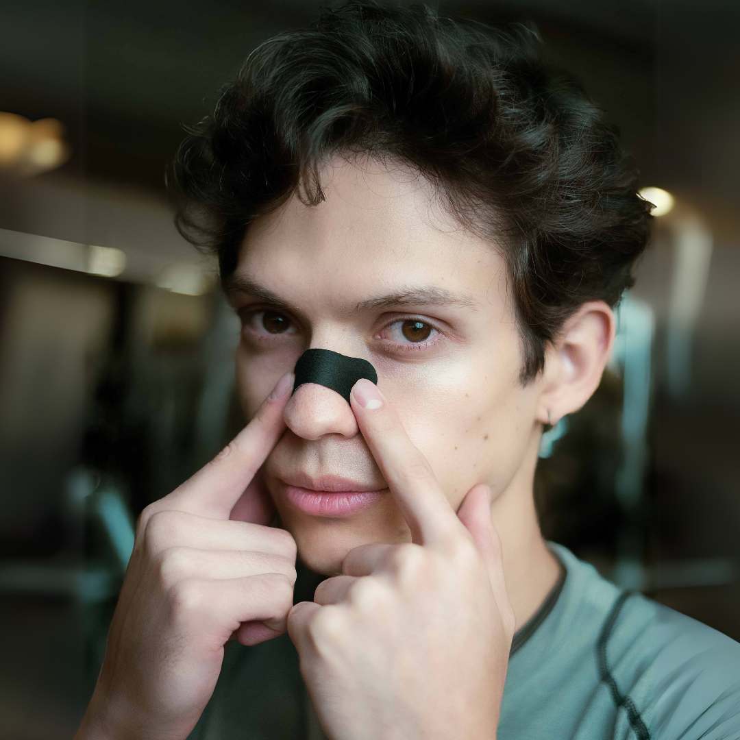 Tiras Nasales biOptimización - Variante Negro - Hombre aplicándose la tira nasal en la nariz