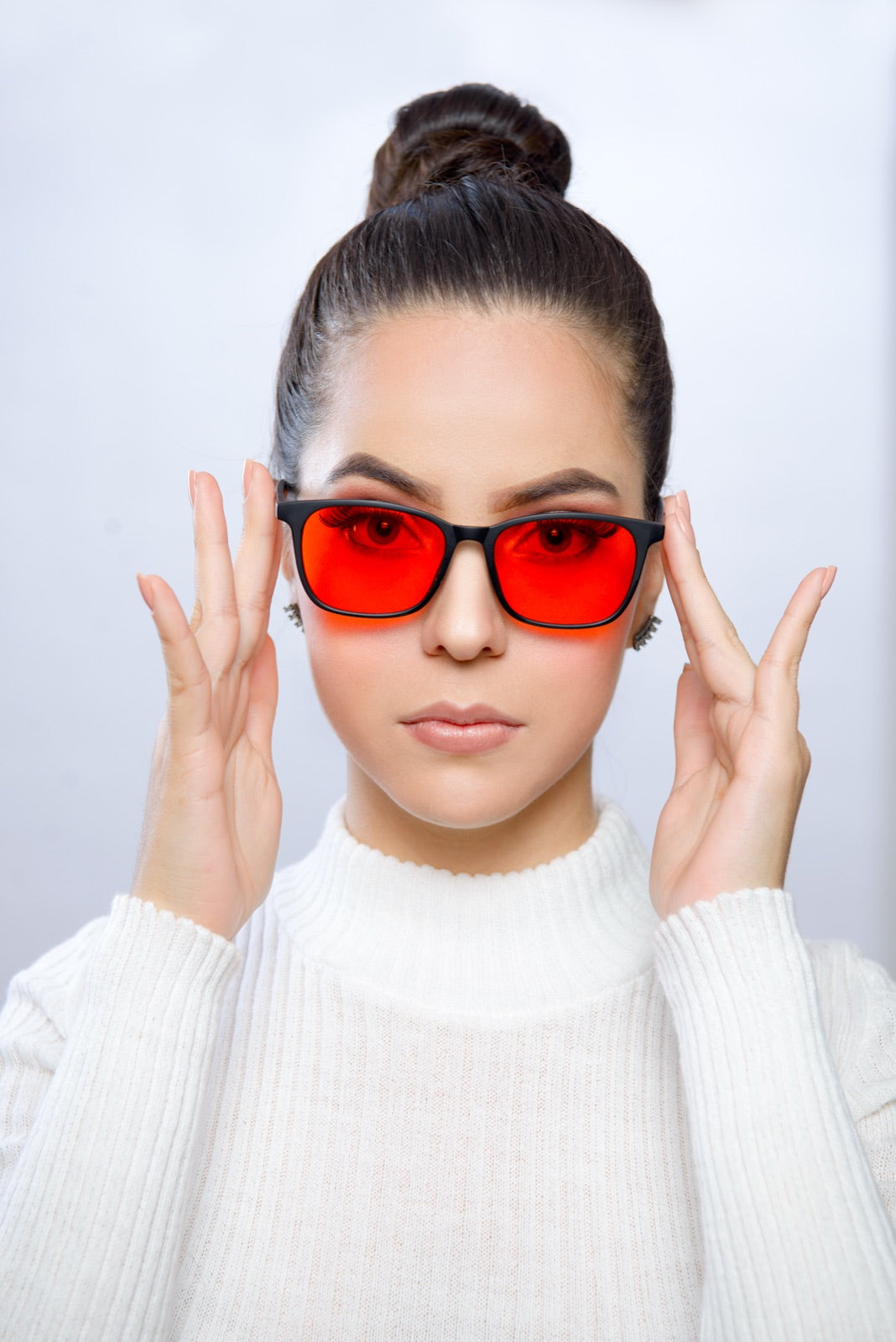 Mujer ajustándose los lentes Alpha + Sueño en estudio