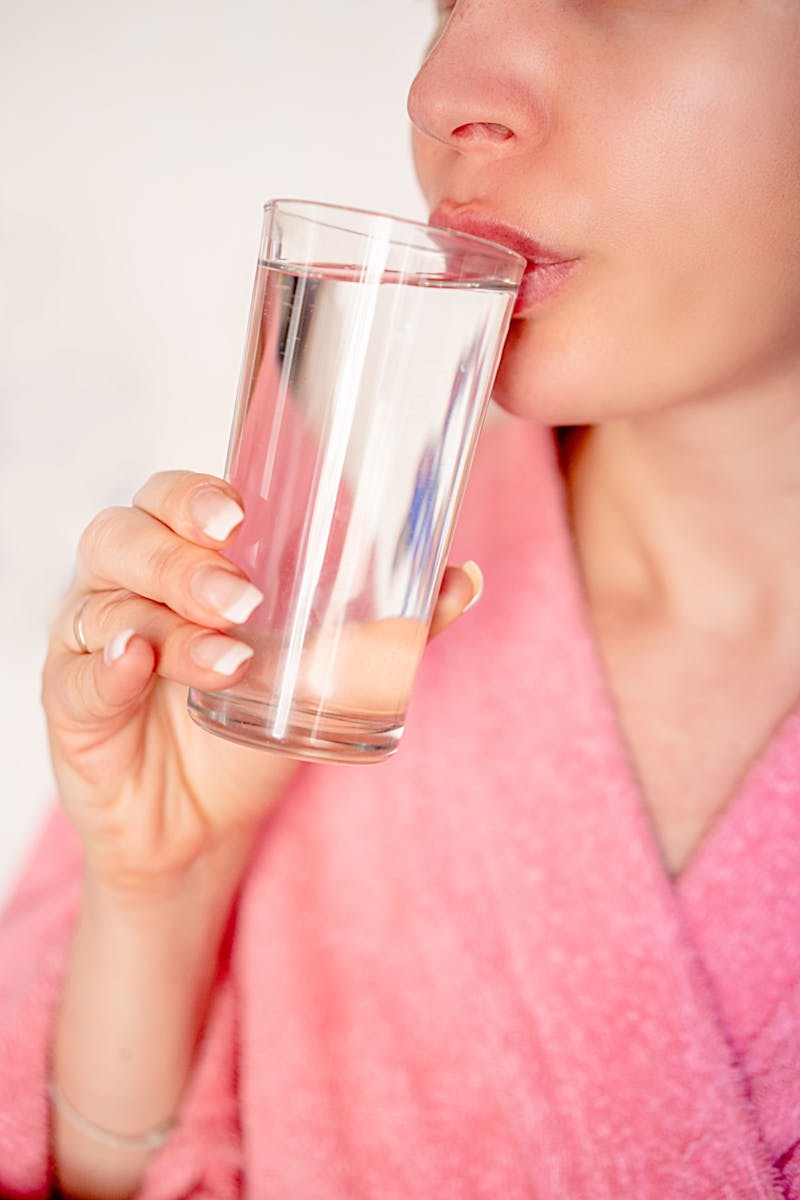 Mujer tomando agua en la mañana - sequedad bucal