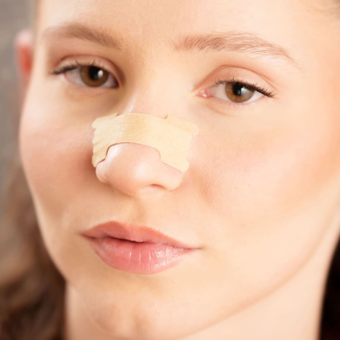 Tiras Nasales biOptimización - Variante Color Piel - Modelo mujer con tira nasal aplicada, primer plano de la nariz