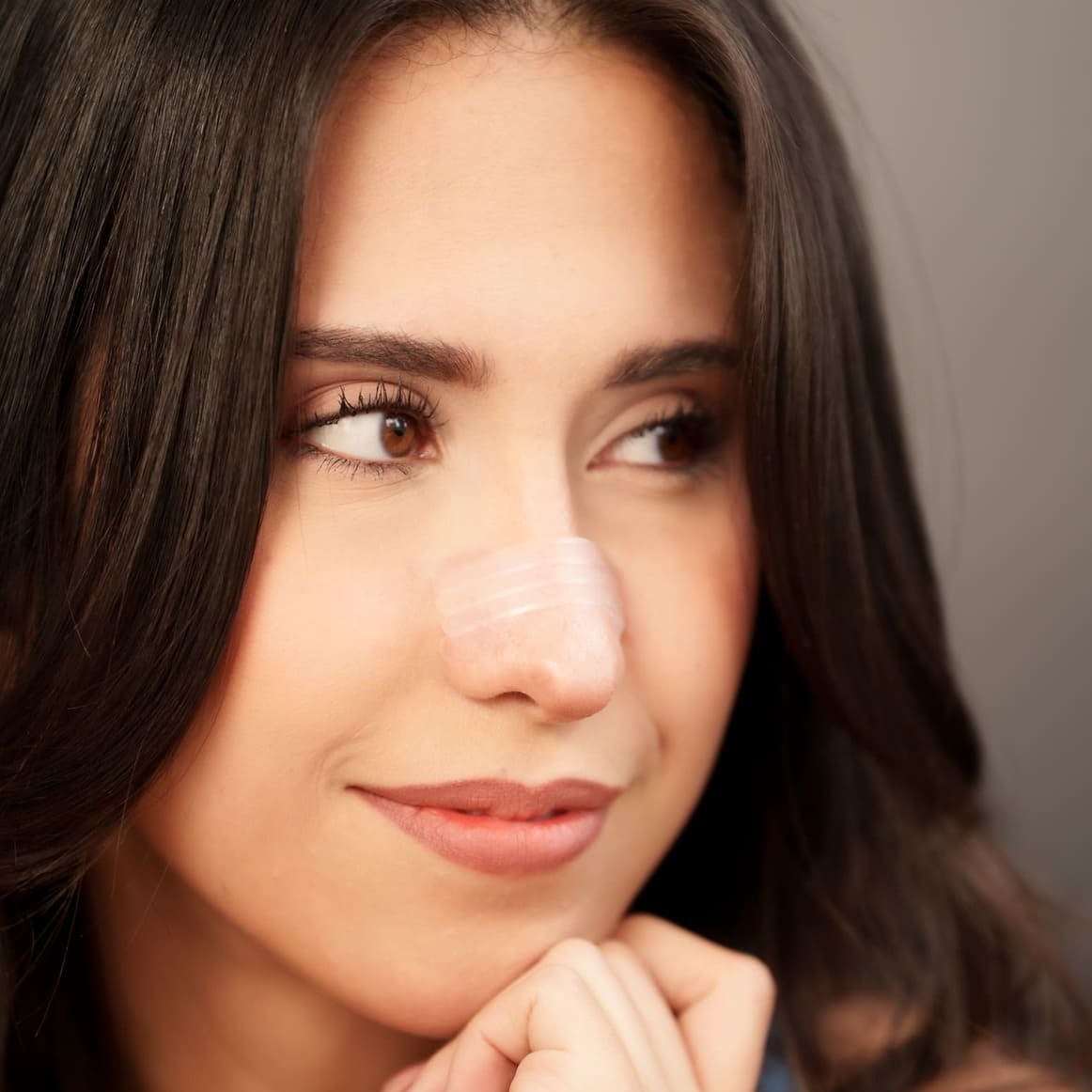 Tiras Nasales biOptimización - Variante Color Piel - Mujer latina con tira nasal aplicada en primer plano - Discreta y efectiva para el día a día