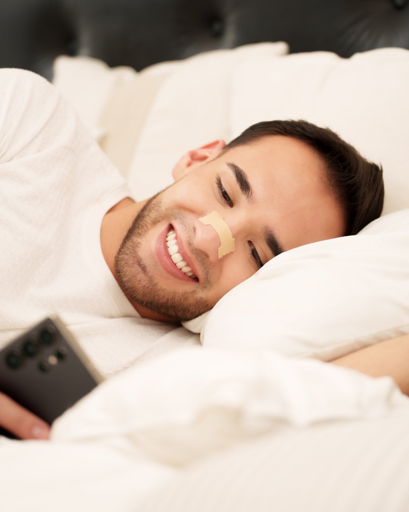 Hombre descansando en cama con la tira nasal puesta