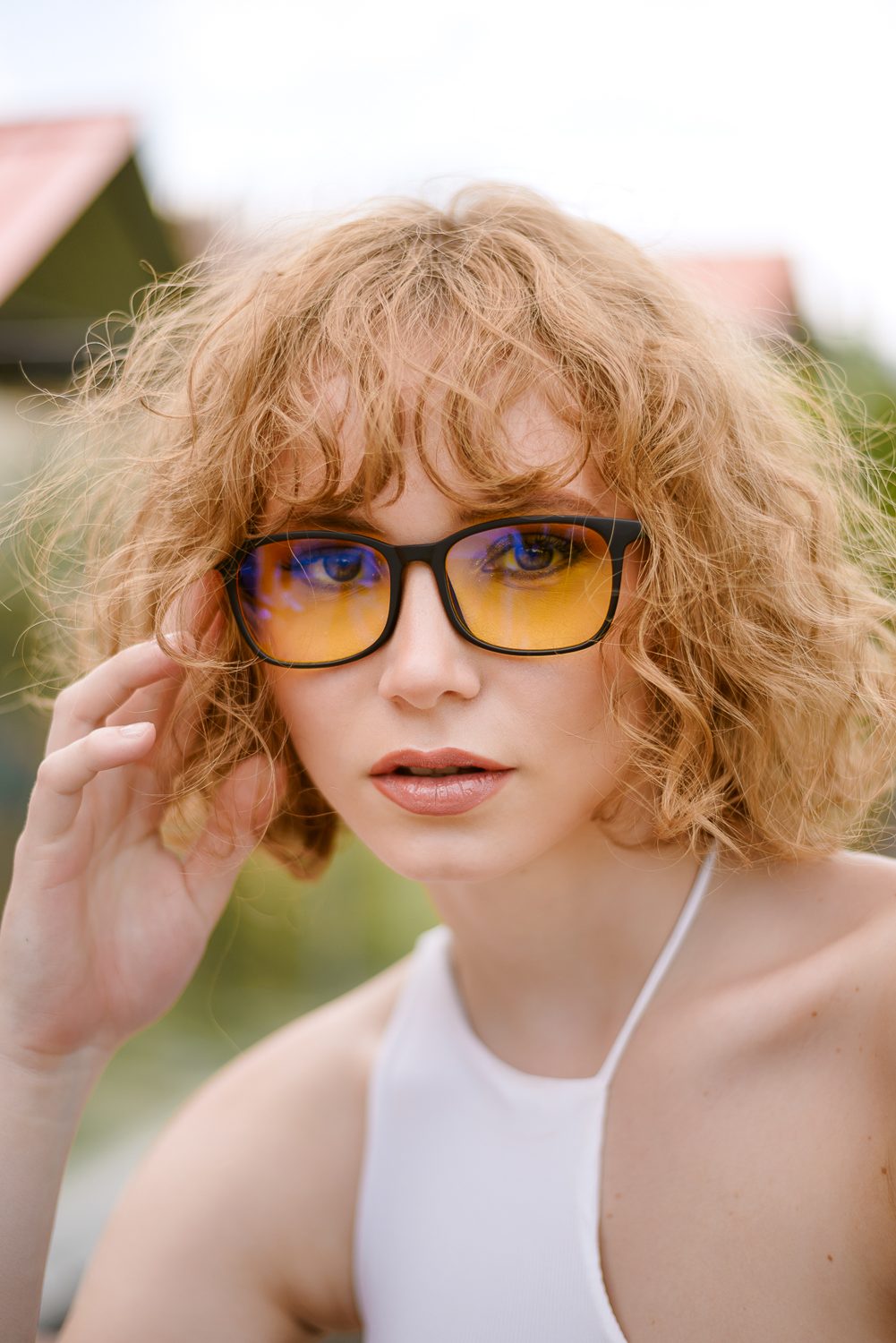 Mujer al aire libre, con luz de sol, usando los lentes Alpha Clarity+
