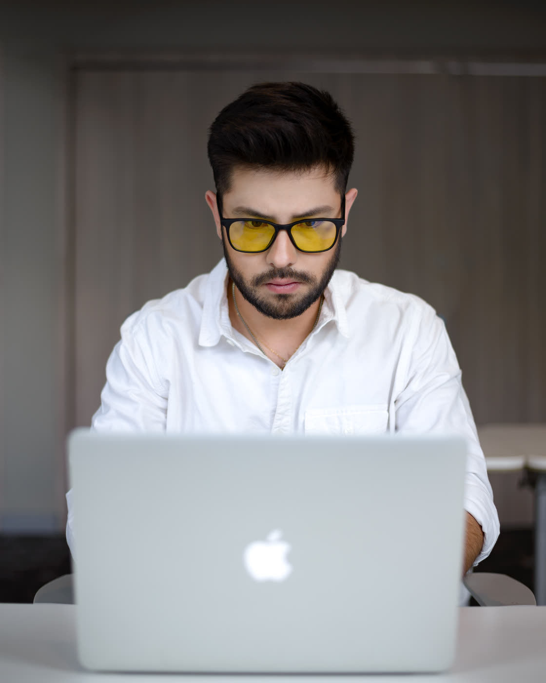 Hombre concentrado trabajando en su laptop con los lentes Alpha Clarity puestos