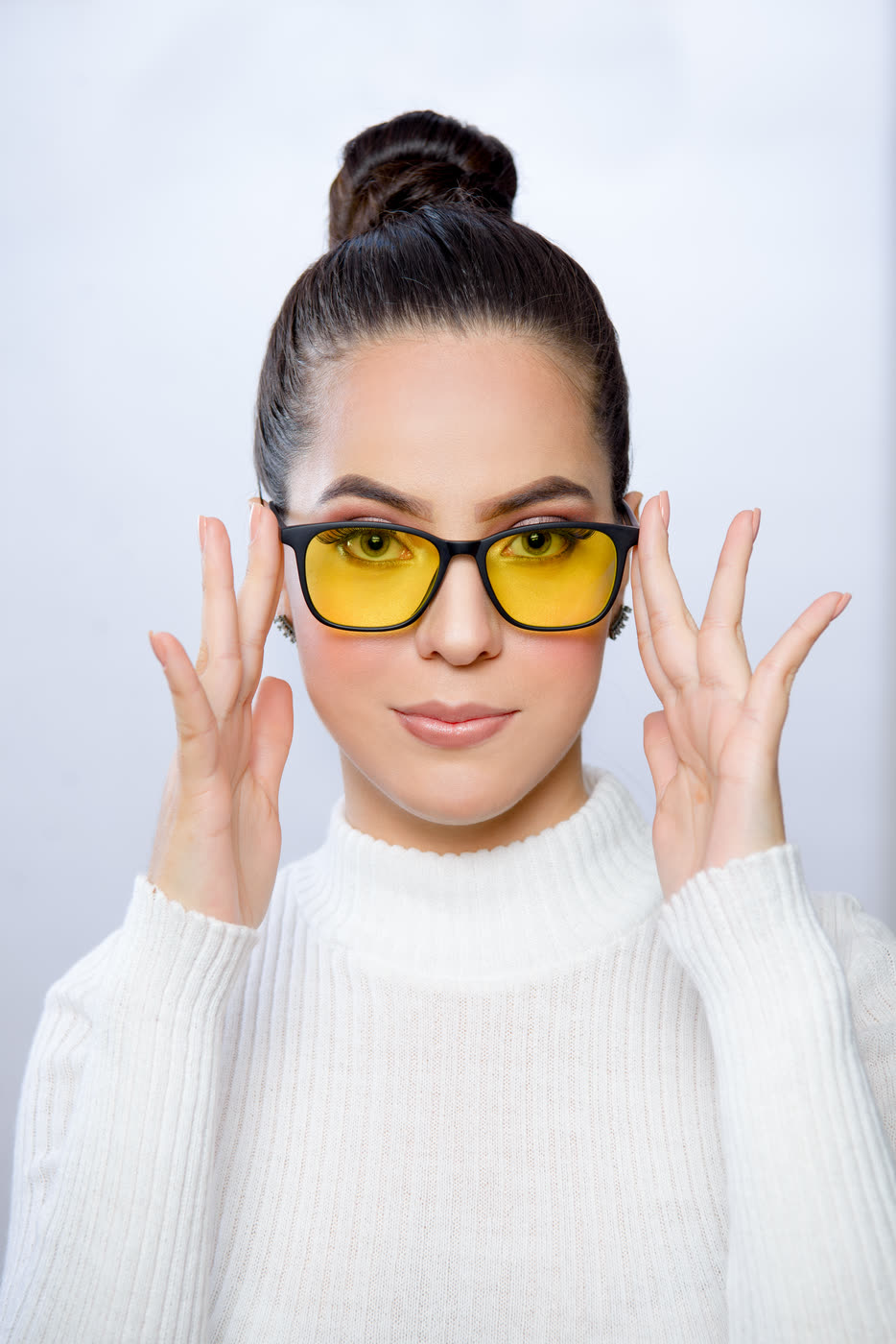 Mujer de frente con los lentes Alpha Clarity puestos, sosteniendo las varillas