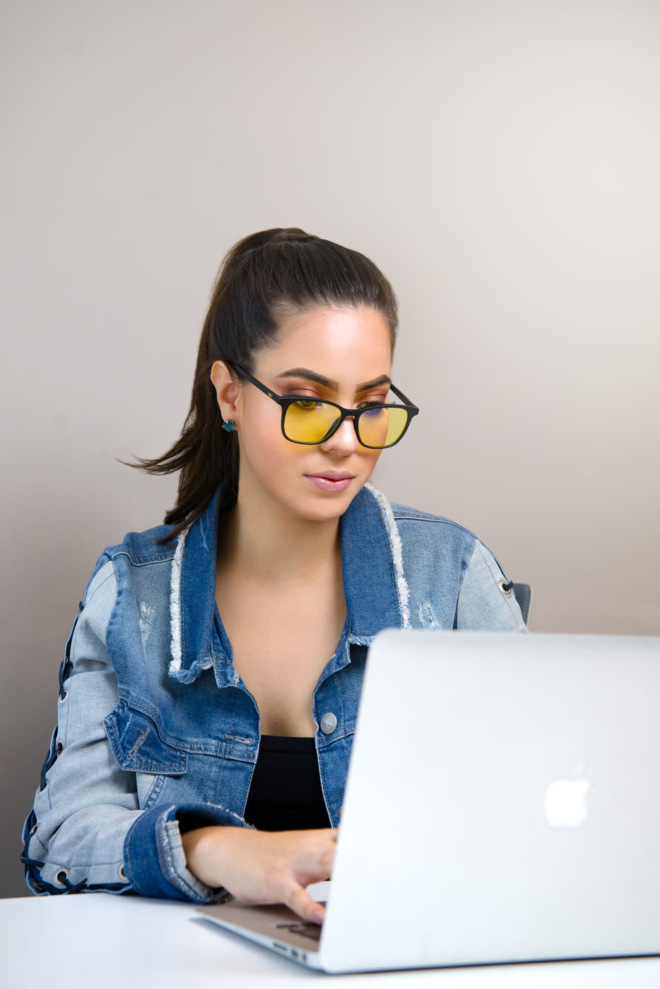 Mujer escribiendo en su laptop con los lentes Alpha Clarity puestos