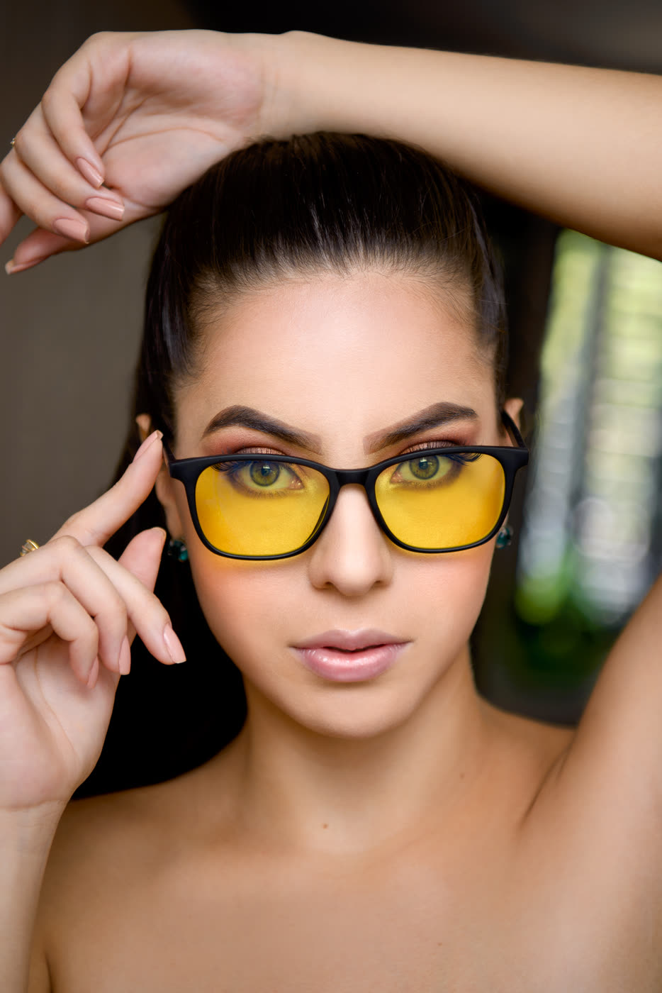 Primer plano de una mujer de frente con los lentes Alpha Clarity: se ven ambos ojos a través del lente amarillo