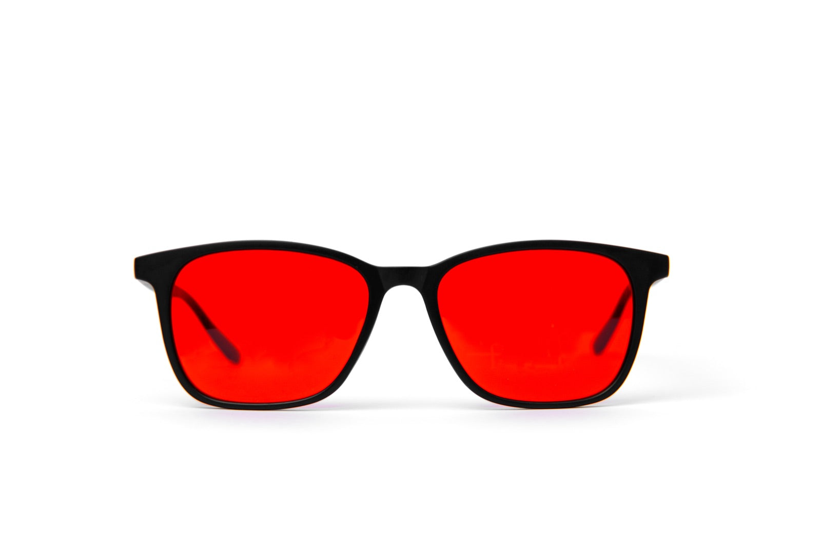 Lentes Alpha + Sueño de frente sobre fondo blanco: montura negra mate con lente rojo de noche