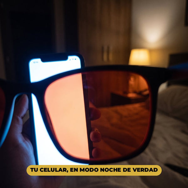 Vista a través del lente rojo, de noche en la cama: dentro del lente, la pantalla del celular se ve rojiza; afuera, blanca y brillante